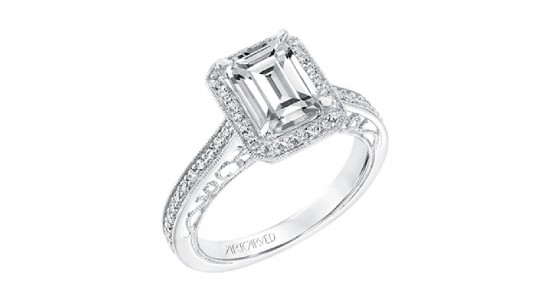 A silver vintage-inspired engagement ring with an emerald cut center stone