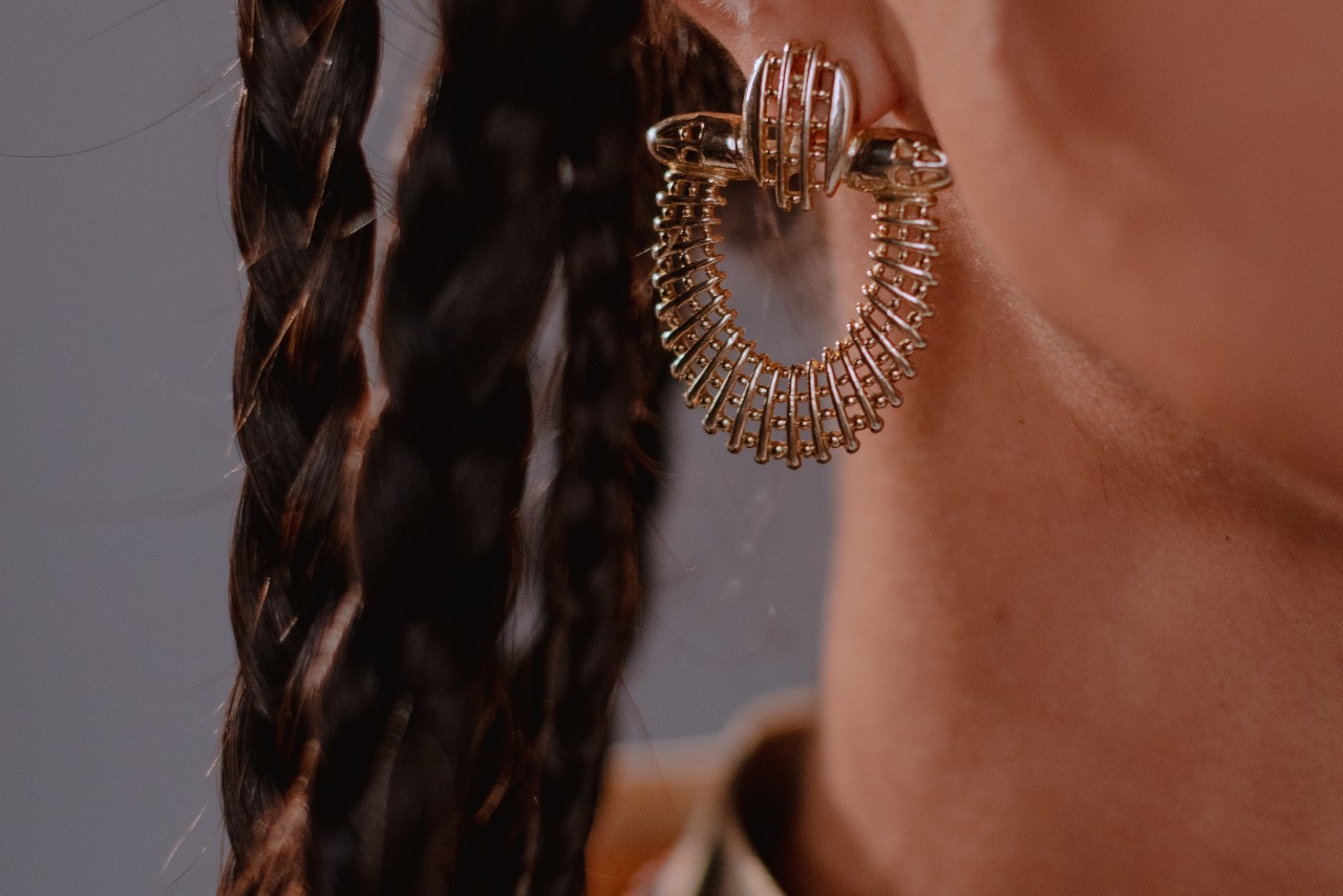 close up image of a woman wearing an elaborate gold earring