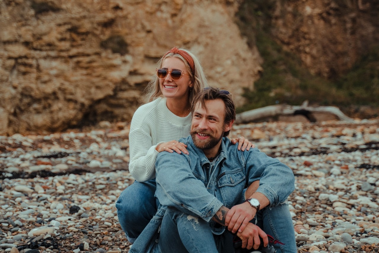 A couple sits down while on a fall vacation hike