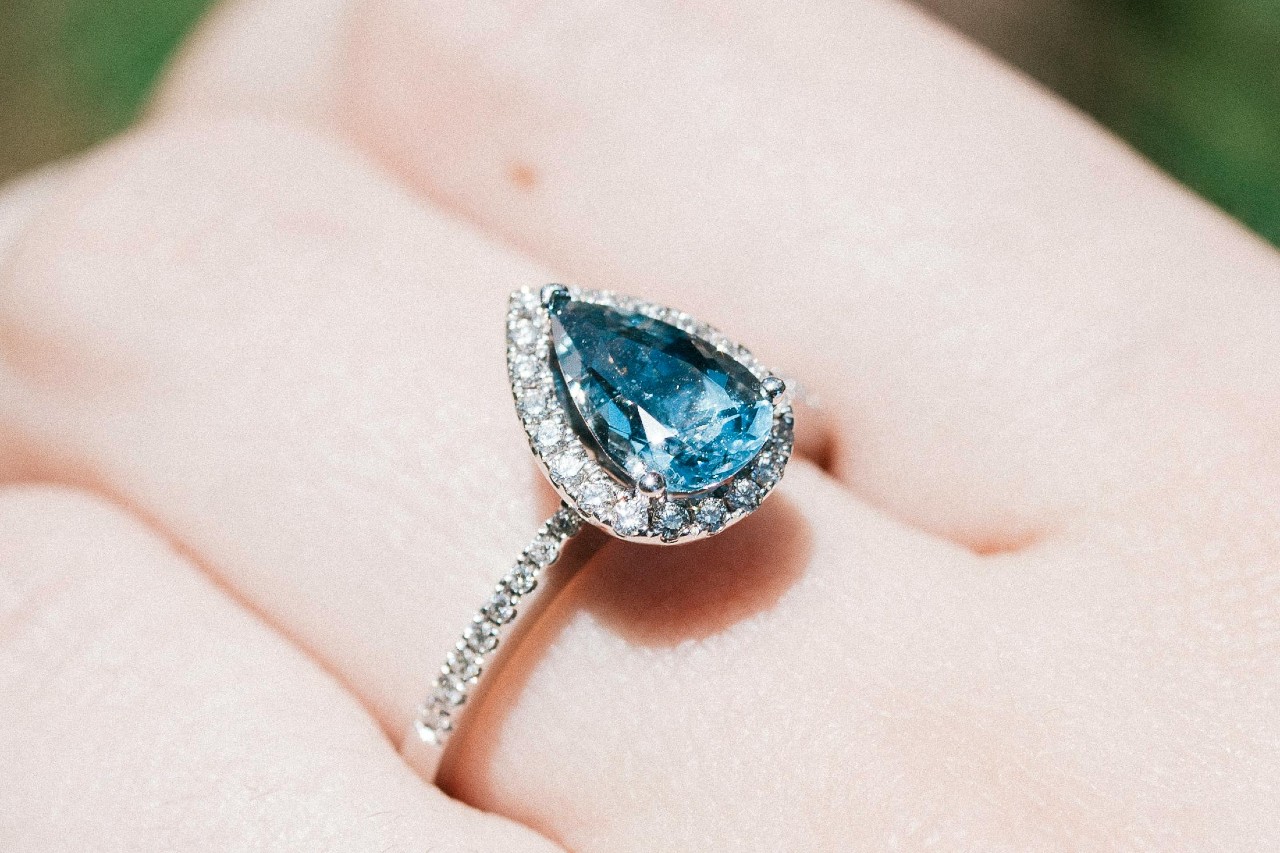 close up image of a woman’s hand wearing an aquamarine fashion ring