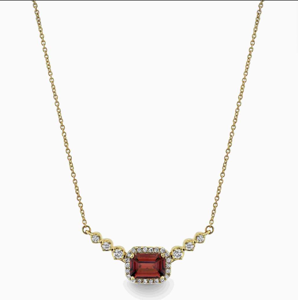 A yellow gold bar diamond necklace with garnet center stone
