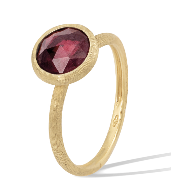 A yellow gold bezel set fashion ring with round garnet center stone