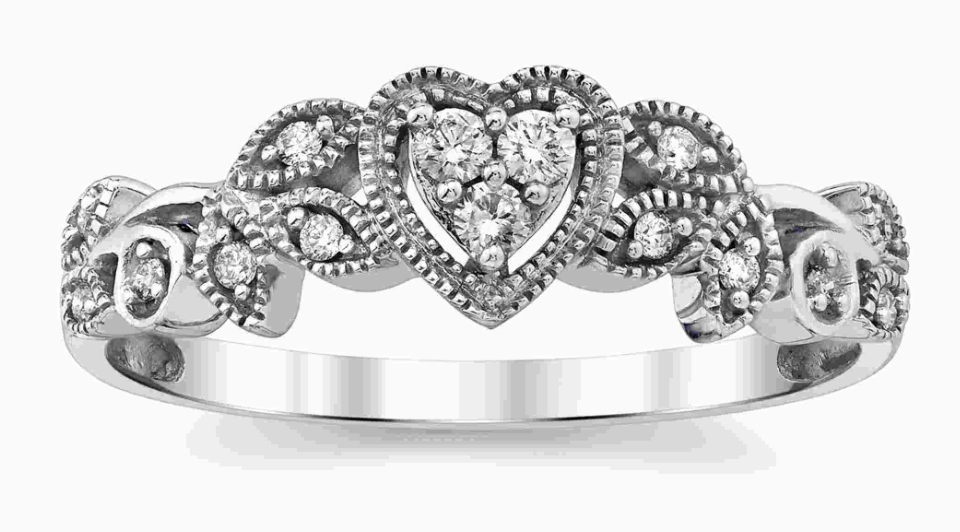 A white gold vintage ring with heart and flower motifs, encrusted with diamonds
