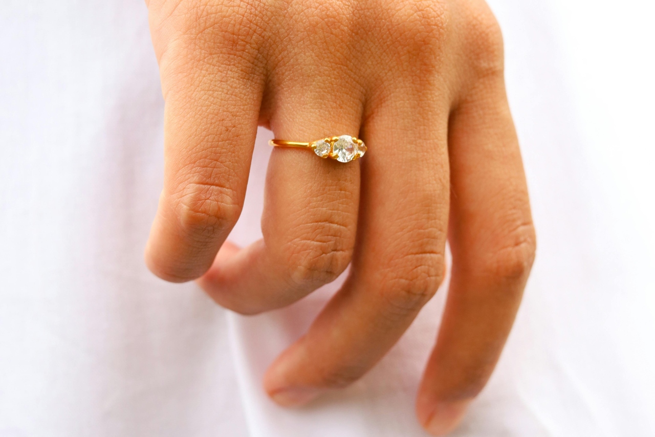 A three stone diamond ring on a thin yellow gold band