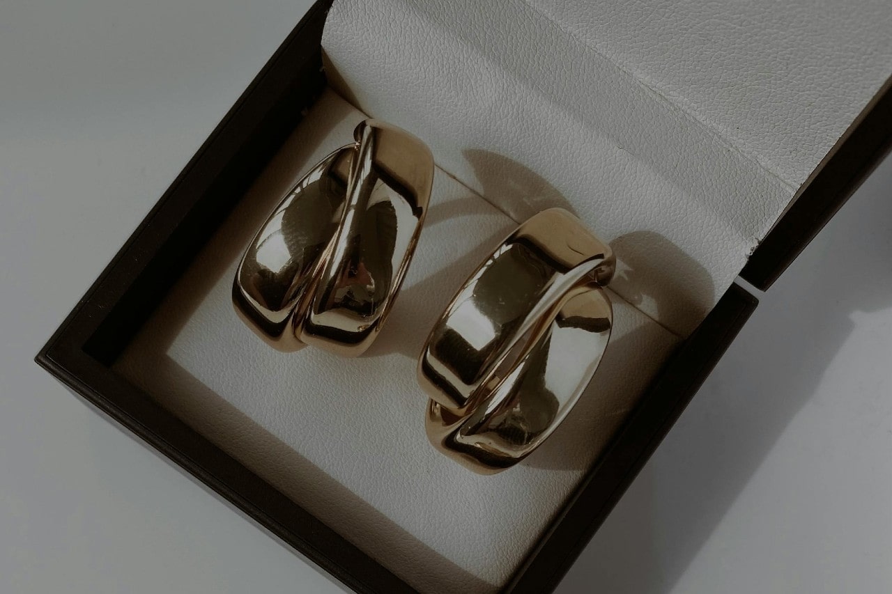 a pair of chunky silver hoop earrings in a black gift box