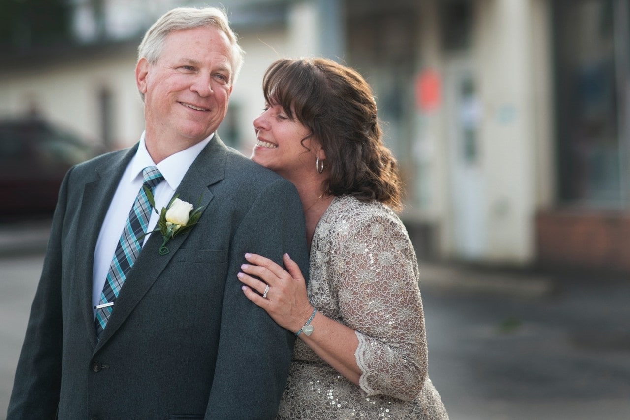 an older couple dressed in formal clothes and embracing