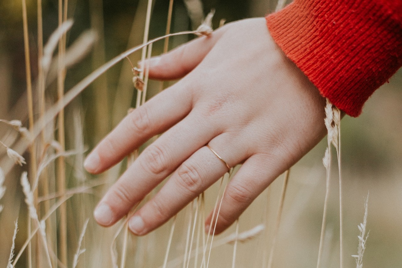 a slender yellow gold band on a woman’s hand