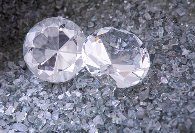 two diamonds sitting among a bed of shattered diamond shards