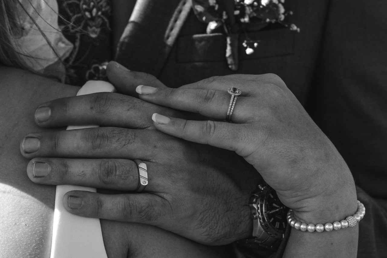 A close-up of a couple’s hands, adorned in elegant jewelry.