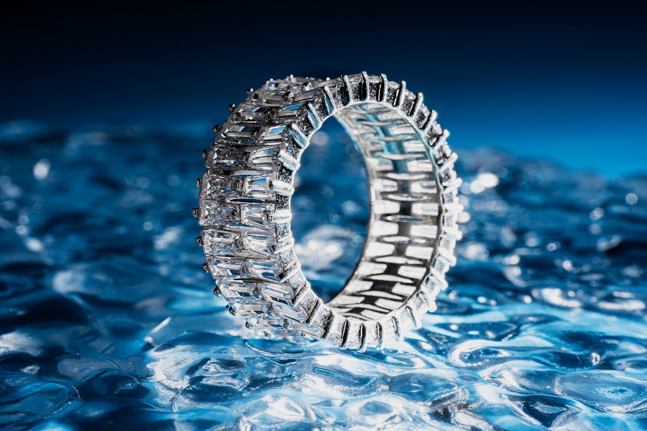 A close-up of a spectacular side stone ring displayed on its side on a block of carved ice.