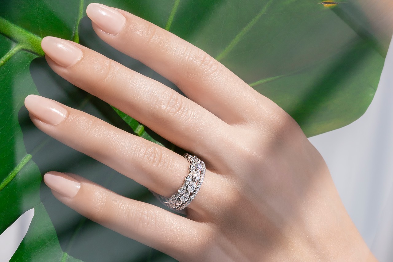 A woman wearing a TACORI wedding band stack with multiple diamond shapes and detail