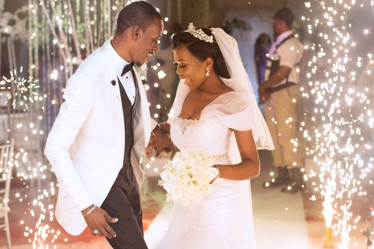 A couple dancing at their wedding with sparklers and bright twinkling lights surrounding them.