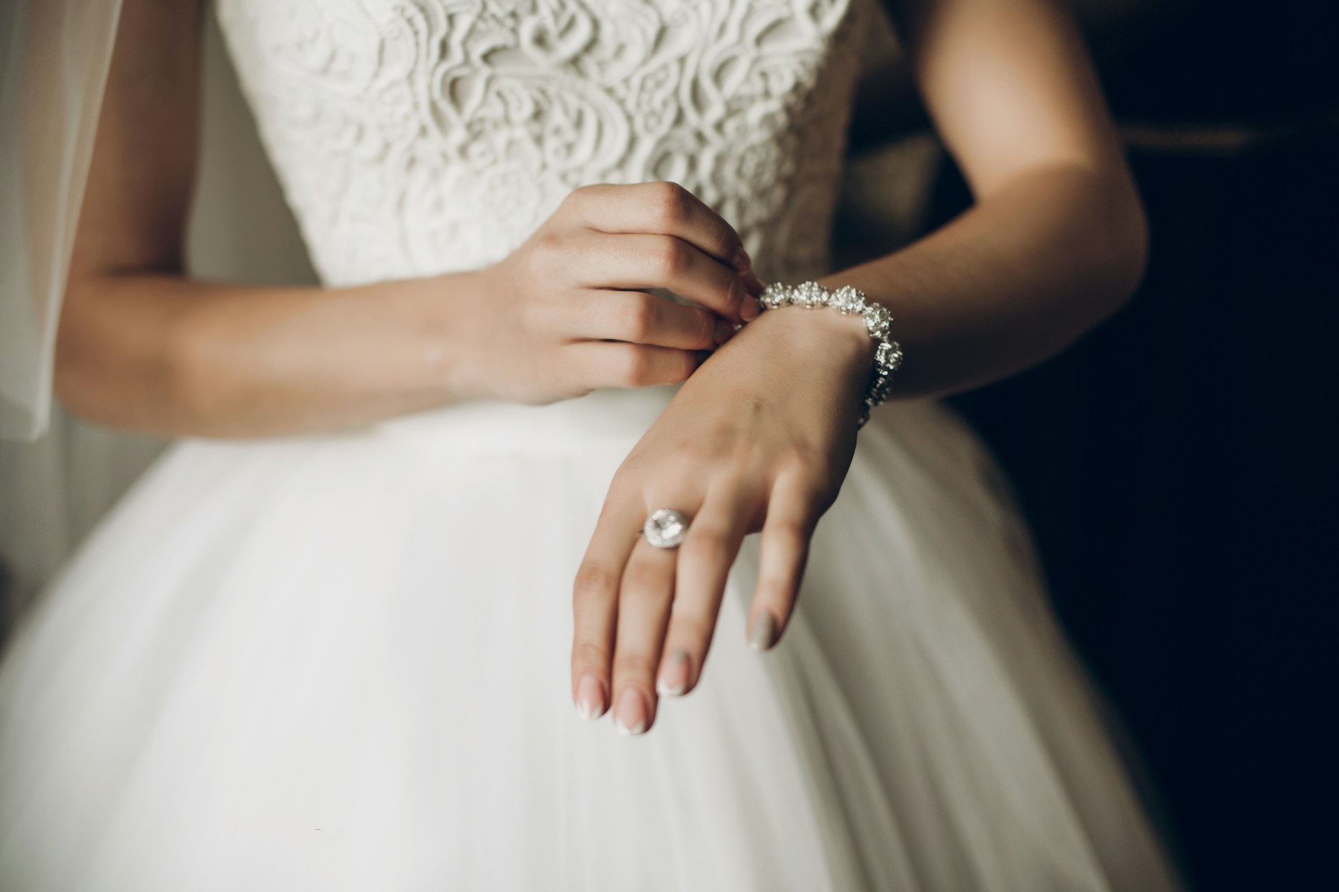a bride putting on a diamond bracelet a bride putting on a diamond bracelet