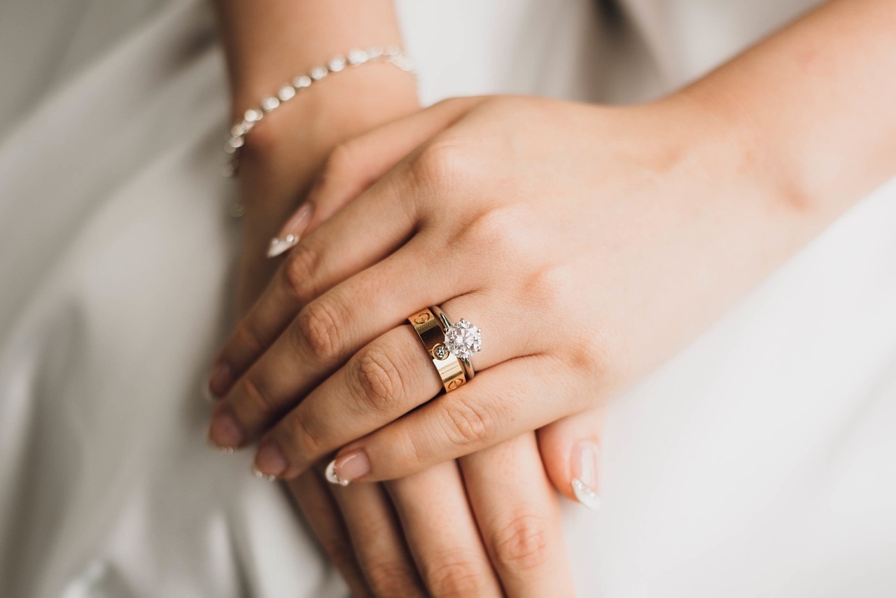 A bride hands wearing engagement ring and wedding band A bride hands wearing engagement ring and wedding band