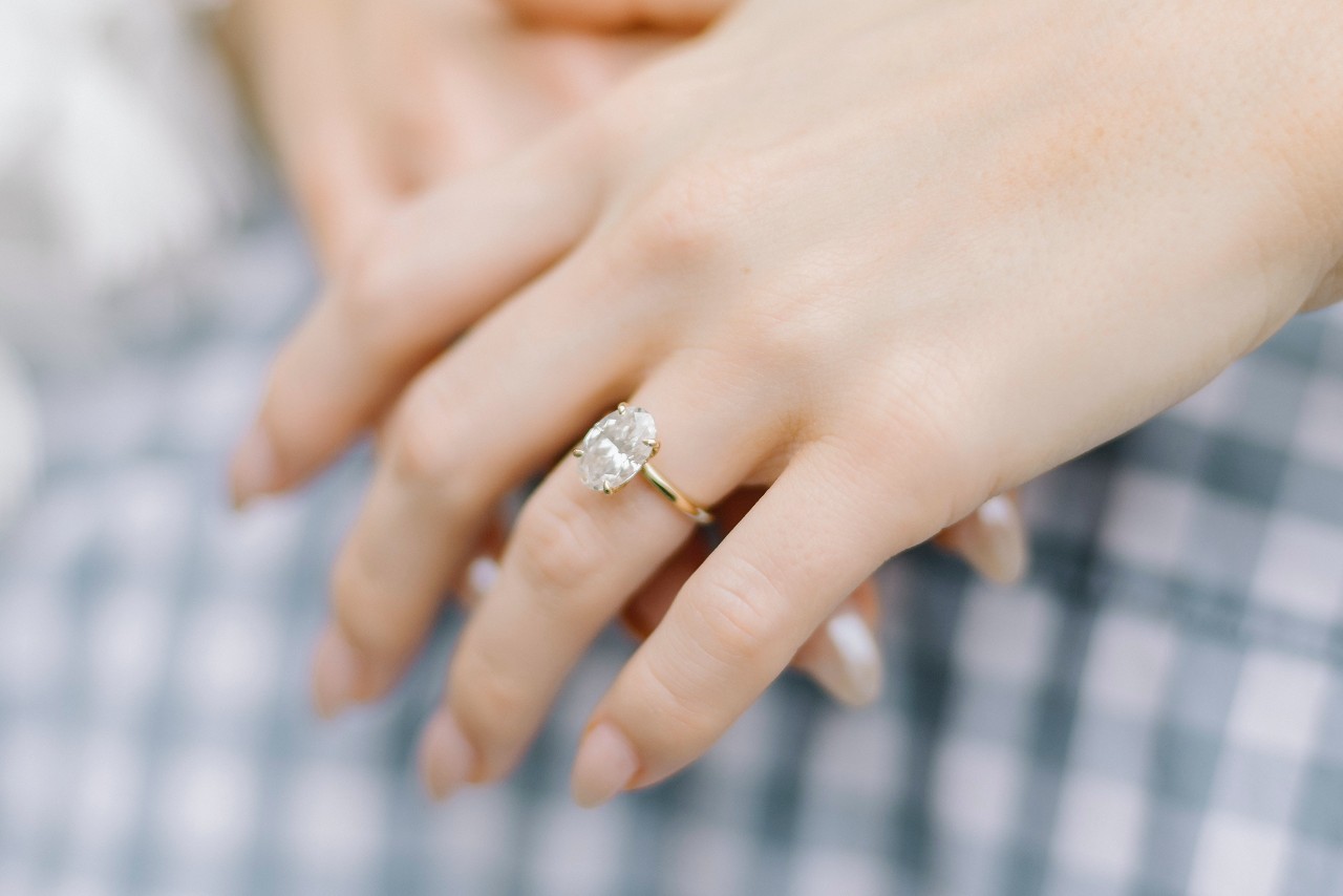 a lady’s hand wearing a solitaire ring with prong setting a lady’s hand wearing a solitaire ring with prong setting