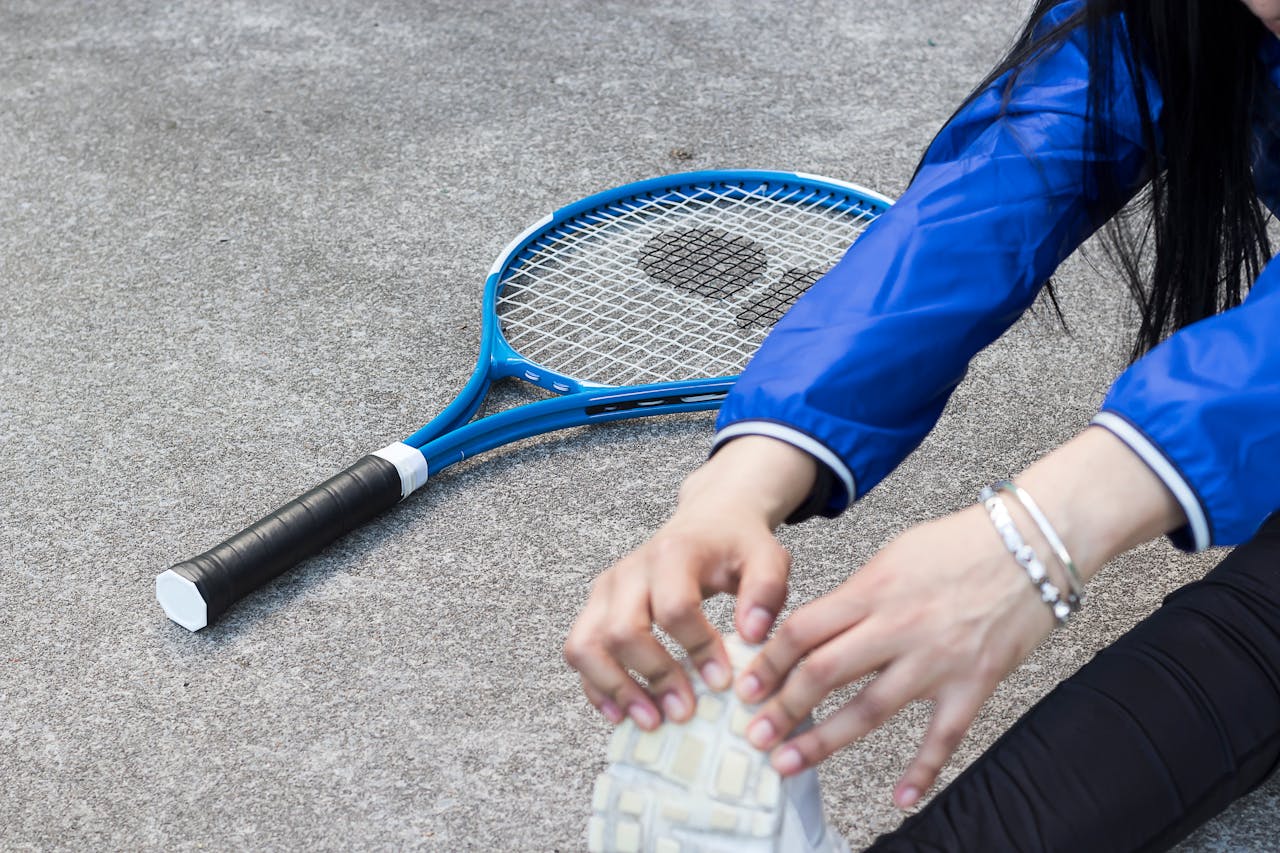 A view of a tennis player stretching before a match, wearing a tennis bracelet on her left wrist. A view of a tennis player stretching before a match, wearing a tennis bracelet on her left wrist.